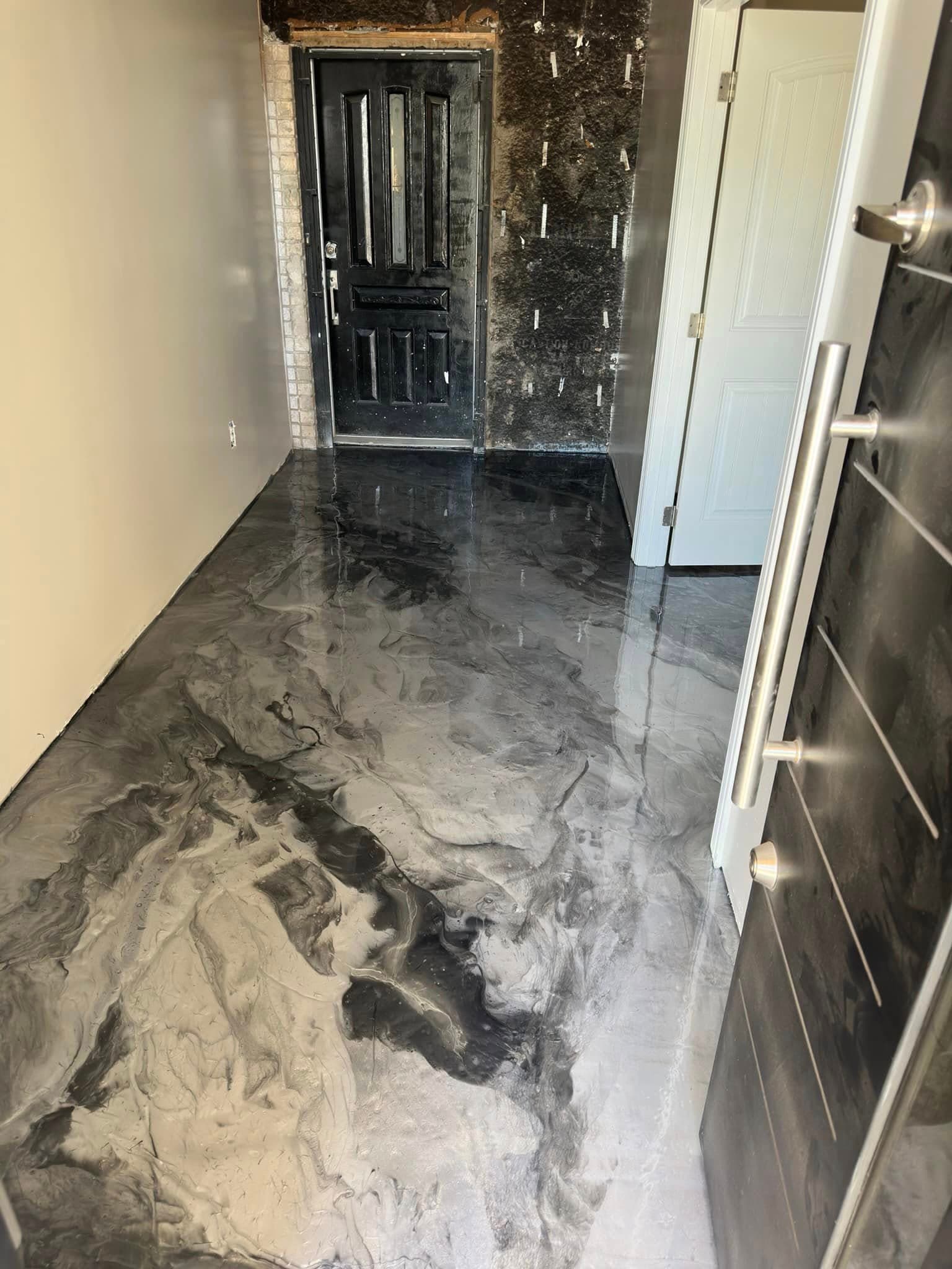Silver-and-black metallic epoxy entry floor reflecting a doorway.